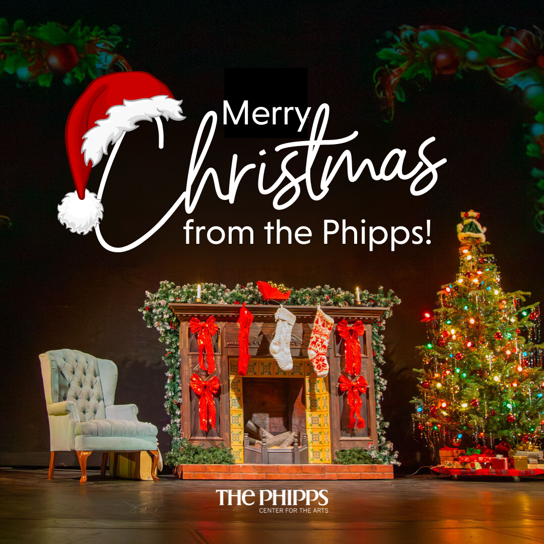 Merry Christmas from The Phipps with a photo of a christmas tree, christmas-decorated fireplace, and lounge chair all on a stage.