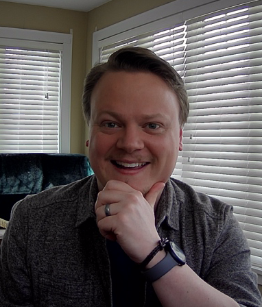 Brian, an extremely handsome blonde and goateed man, smiling at the camera in his office.